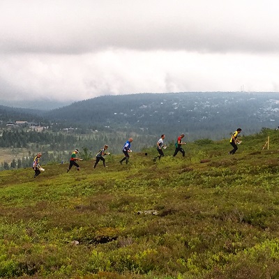 Orienteers in a row in the mountains